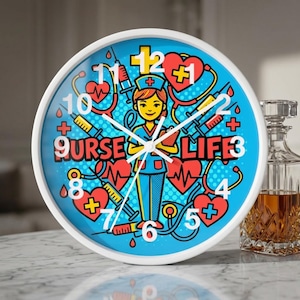 May include: A round wall clock with a white frame and a blue face. The clock face features a cartoon nurse illustration with the words "NURSE LIFE" and medical-themed graphics. The clock hands are white.