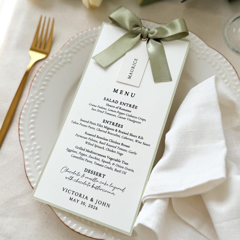 Elegant sage green bordered wedding menu card with satin ribbon bow and place card for a refined table setting