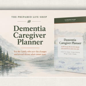 May include: A book titled "Dementia Caregiver Planner" with a landscape illustration of a lake and mountains. The cover text includes "For the family who sees the changes and doesn't know what comes next." The book is from The Prepared Life Shop.