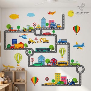 Peut inclure: Un ensemble d'autocollants muraux représentant un réseau routier gris sinueux avec des véhicules de dessin animé colorés, des camions, des voitures, des bus, des engins de chantier, des bâtiments, des montgolfières et des panneaux de limitation.