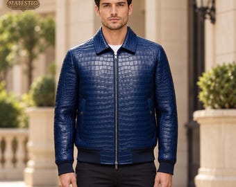 May include: A deep blue jacket featuring a textured crocodile skin pattern, a classic collar, and a full-length silver metal zipper. The garment includes dark blue ribbed cuffs and a matching ribbed hem, providing a structured fit.