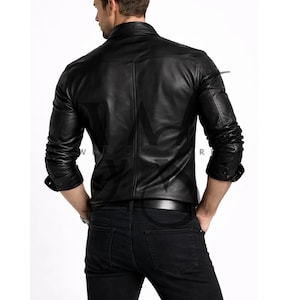 Pu&ograve; includere: Giacca in pelle nera con chiusura a bottoni e maniche lunghe. La giacca ha un design classico con colletto e vestibilit&agrave; sartoriale. Il modello indossa jeans neri e una cintura nera. La giacca &egrave; un capo di abbigliamento versatile.