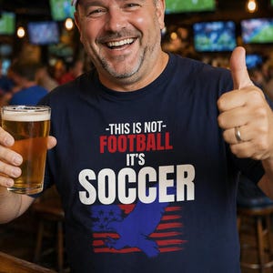 Man wearing USA soccer shirt saying This Is Not Football It's Soccer funny American fan tee in sports bar