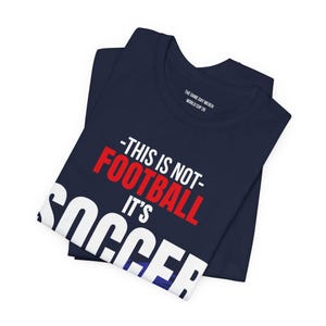 Folded navy blue USA soccer shirt with This Is Not Football It's Soccer graphic casual fan apparel