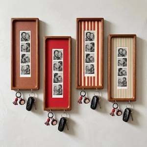 May include: Four rectangular wooden wall-mounted key holders, each featuring a vertical photo strip of a couple. The frames have solid red, striped red, or striped green backgrounds. Each frame includes two metal hooks holding keys and tassels.