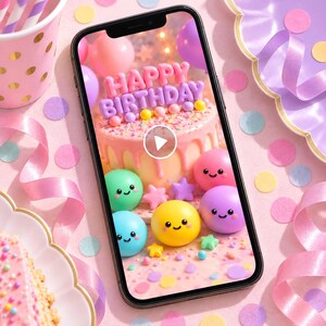 May include: A black smartphone displaying a video of a pink birthday cake with the text Happy Birthday, surrounded by colorful smiling spheres and star-shaped decorations, set against a background of pink party supplies and confetti.
