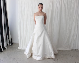 Vestido de novia de corte A sin tirantes, estilo princesa, de satén de seda duquesa color marfil, de Vera Wang, estilo vintage de los 90, con delicados botones en la espalda.