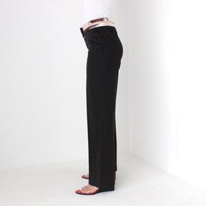 May include: A pair of dark brown straight-leg pants with a brown belt.