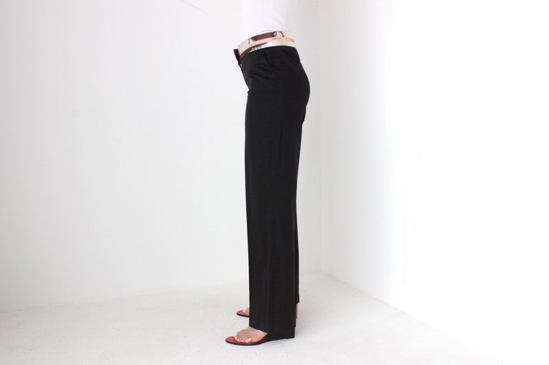 May include: A pair of dark brown straight-leg pants with a brown belt.
