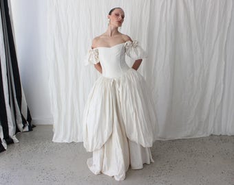 Vestido de novia vintage de los años 90 de seda dupión de 1992 con cintura tipo vasco, hombros abullonados y elaborado drapeado, adornado con rosetas.