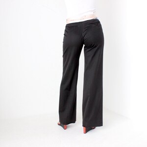 May include: Black wide-leg pants with a high waist and a belt loop.