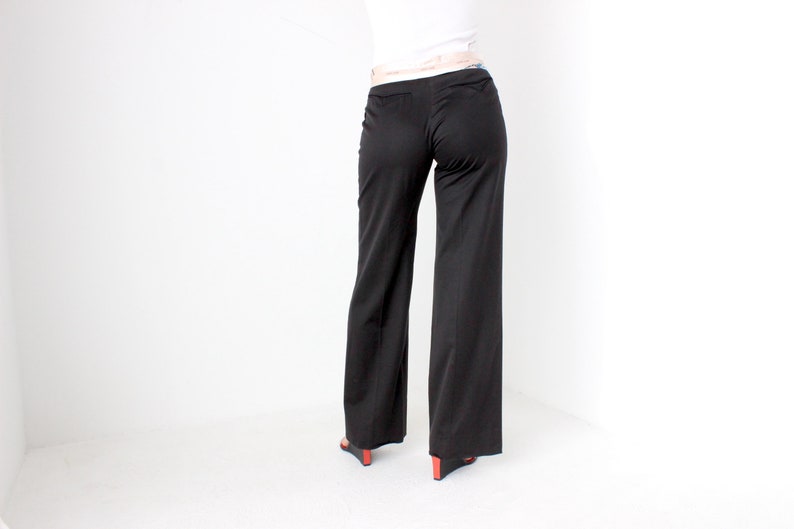 May include: Black wide-leg pants with a high waist and a belt loop.