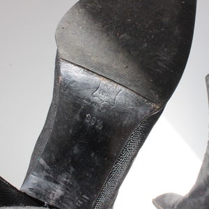 May include: Black mesh ankle boots with a pointed toe and a block heel. The sole of the boot is marked with "Made in Italy" and "9 1/2".