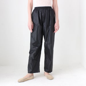 Può includere: Pantaloni neri in nylon con elastico in vita.