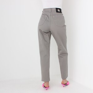 May include: Gray high-waisted jeans with a black label on the back.