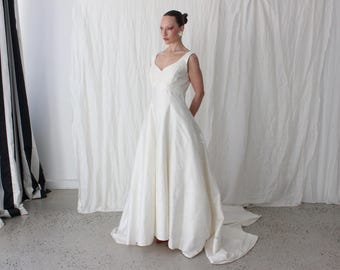 Vestido de novia británico vintage de los años 90, de seda cruda color marfil, corte imperio, corte en A, con corpiño y cola de jacquard.