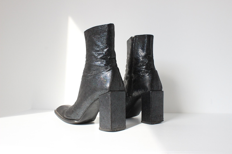 May include: A pair of black ankle boots with a chunky heel and a glittery finish.