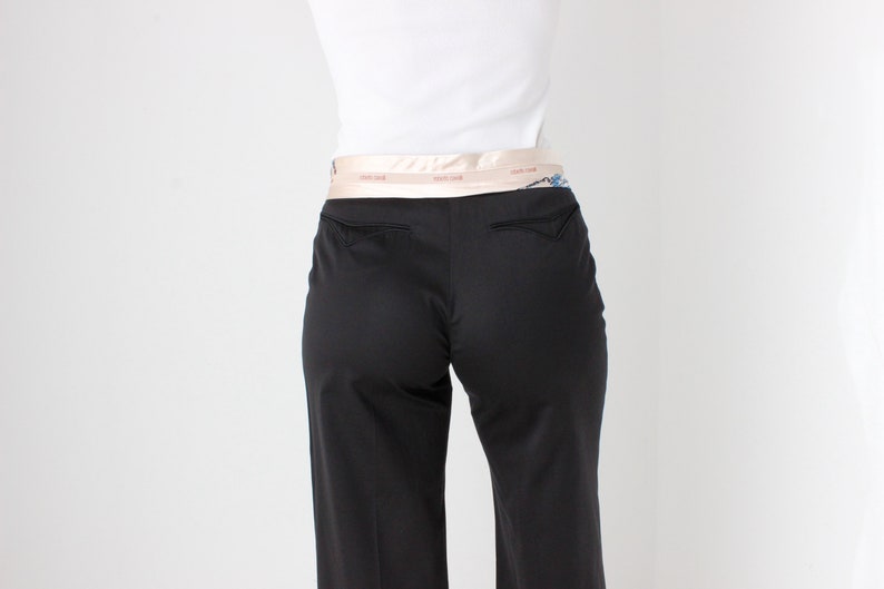 May include: Black pants with a wide leg and a light pink satin belt.
