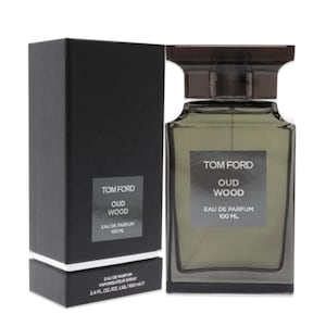 May include: A Tom Ford Oud Wood Eau de Parfum bottle and box set. The rectangular perfume bottle is olive green with a dark cap. The box is black with white text. The text on the bottle reads "Tom Ford Oud Wood Eau de Parfum 100 ML".