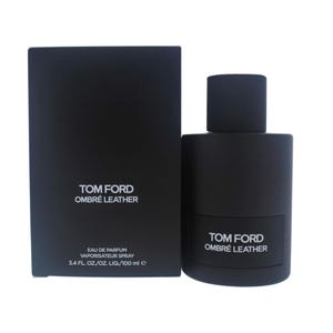 May include: A black Tom Ford Ombré Leather Eau de Parfum spray bottle and box. The bottle is cylindrical with a black cap. The box and bottle both feature the text "TOM FORD OMBRÉ LEATHER". The bottle contains 3.4 fl oz / 100 ml.