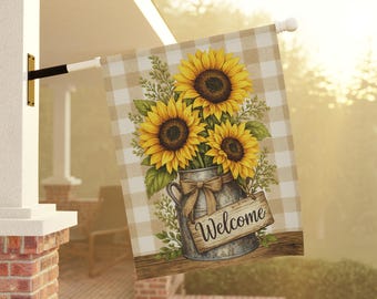 May include: A decorative outdoor flag featuring a watercolor illustration of sunflowers in a galvanized metal vase with a bow and a wooden sign that says "Welcome". The background is a tan and white checkered pattern.