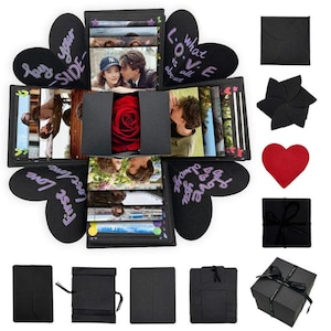May include: A black explosion gift box that unfolds to reveal multiple photo panels, heart-shaped flaps with handwritten text like 'Love is all about', and a central compartment containing a red rose. Includes various black paper accessories.