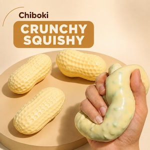 May include: Three light yellow peanut-shaped squishy toys with textured shells and one pale yellow squishy toy being squeezed. The text Chiboki CRUNCHY SQUISHY is visible at the top. The objects are light yellow and have a smooth, pliable texture.