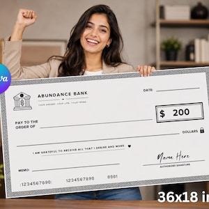 May include: A large white novelty check measuring 36 by 18 inches with a black Greek key border. It features the text Abundance Bank, a bank icon, a dollar amount box labeled $ 200, lines for date, payee, and signature, and the phrase I am grateful to receive all that I desire and more.