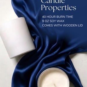Pode incluir: Uma vela cil&iacute;ndrica branca e uma vela acesa em um recipiente prateado s&atilde;o exibidas em um tecido de cetim azul escuro. O texto "Candle Properties" est&aacute; no topo, com detalhes: 40 horas de tempo de queima, 255 g de cera de soja e vem com tampa de madeira.