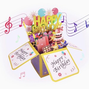 May include: A pop-up birthday card with a gold glitter "Happy Birthday" message. The card features a cake, gifts, and balloons. The card is purple and yellow with the words "Happy Birthday" on the front.