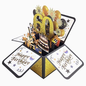 May include: A pop-up birthday card with a gold glitter "60" in the center. The card features a cake, gifts, balloons, and the words "Happy Birthday". The card is black, gold, and white.