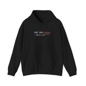 May include: Black hoodie with a front pocket and drawstring. The hoodie features the text "DROP TABLE monday;" in white and orange, followed by lines of code. The design is a humorous take on programming.