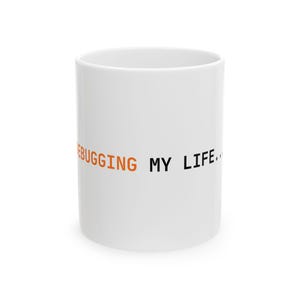 Peut inclure: Un mug en céramique blanc avec le texte DEBUGGING en lettres capitales orange suivi de MY LIFE... en lettres capitales noires. Le mug présente une forme cylindrique avec une finition lisse et un design simple et épuré sur la face avant.