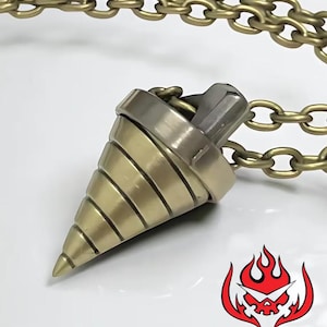 Może przedstawiać: Brązowy wisiorek w kształcie wiertła, zawieszony na pasującym łańcuszku. Wisiorek ma metaliczną srebrną górę i jest umieszczony na białym tle. Czerwono-biała grafika znajduje się w prawym dolnym rogu.