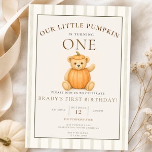 May include: A rectangular birthday invitation card featuring a beige background with vertical stripes. The text reads: Our Little Pumpkin Is Turning One. Please join us to celebrate Brady's First Birthday! October 12, 2:00 PM, The Pumpkin Patch.
