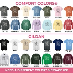 May include: A color chart displaying Comfort Colors 1717 shirts and 1566 sweatshirts, alongside Gildan 5000 shirts and 18000 sweatshirts. Each garment features a graphic with the text All Booked Up and various book-related illustrations in multiple colors.