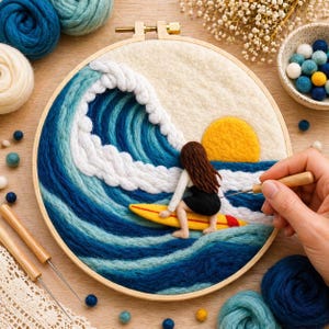 以下が含まれることがあります： 木製のフレームに手作りの刺繍アート。サーファーが黄色のサーフボードで波に乗っている様子を描いています。波は青と白の色合いで表現され、夕日が描かれています。手作りのクラフトプロジェクト。