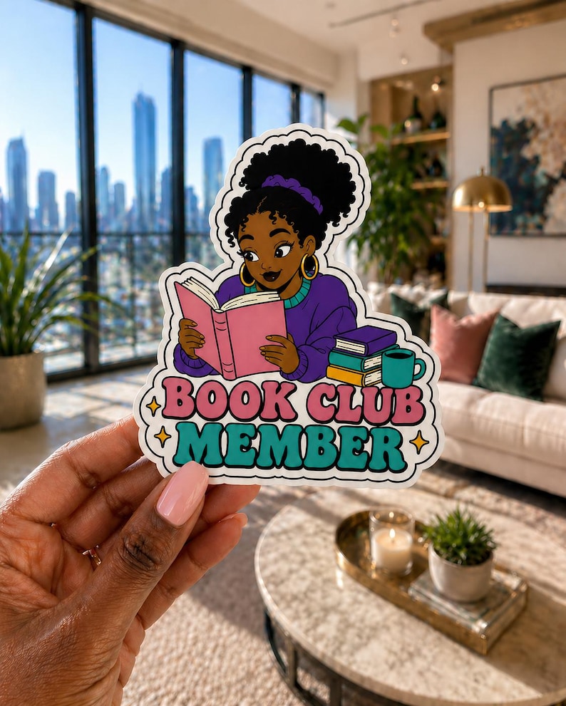 Puede incluir: Una pegatina con una ilustraci&oacute;n de dibujos animados de una mujer negra leyendo un libro rosa. La pegatina tiene el texto "BOOK CLUB MEMBER" en rosa y turquesa. La mujer lleva un su&eacute;ter morado y pendientes de aro dorados.