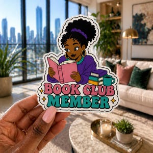 Puede incluir: Una pegatina con una ilustraci&oacute;n de dibujos animados de una persona negra leyendo un libro rosa. La persona lleva un su&eacute;ter morado y pendientes de aro dorados. La pegatina dice "BOOK CLUB MEMBER" en rosa y turquesa.