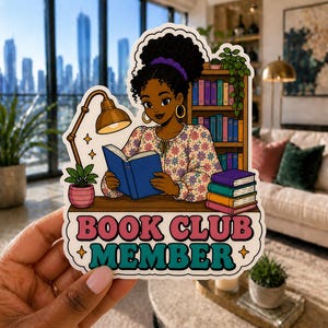 May include: A sticker featuring a cartoon illustration of a person reading a book, with a bookshelf in the background. The sticker reads "BOOK CLUB MEMBER" in pink and teal lettering. The person is wearing a floral top and has dark hair.