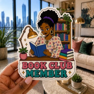 May include: A sticker featuring a cartoon illustration of a person reading a book, with a bookshelf in the background. The sticker reads "BOOK CLUB MEMBER" in pink and teal lettering. The person is wearing a floral top and has dark hair.