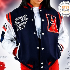 Könnte beinhalten: Marineblaue Collegejacke mit weißen Ärmeln und roten Akzenten. Die Jacke zeigt den Text "Historically Black College Established in 1867" und einen großen "H"-Patch. Teil der "Classic Varsity Style" Kollektion.