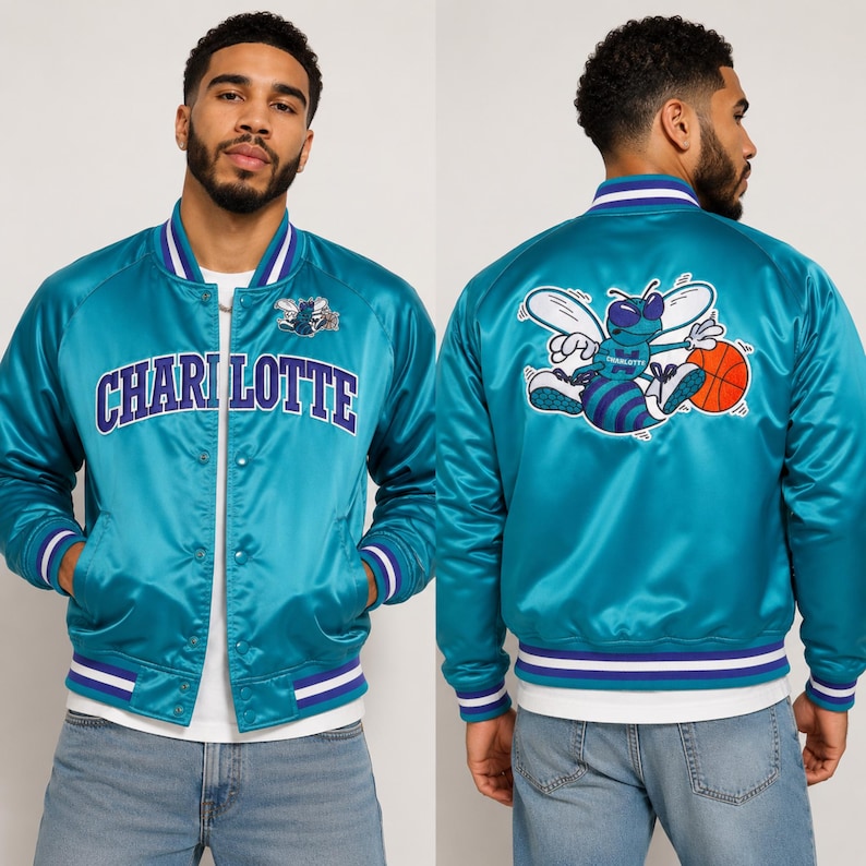 May include: Teal satin bomber jacket with the word "CHARLOTTE" across the chest. The jacket features a white and purple striped collar, cuffs, and hem. The back of the jacket displays a cartoon bee holding a basketball.
