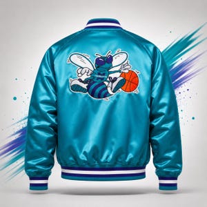 May include: A teal satin bomber jacket with white, blue, and teal striped trim. The back features a cartoon bee graphic holding a basketball, with the word "Charlotte" on the bee's jersey. The jacket has a shiny, smooth texture.