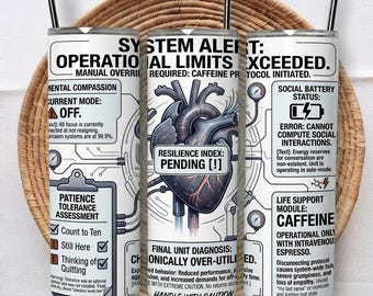 May include: A white cylindrical tumbler with a black straw, featuring a graphic of a human heart at the center. The design includes technical text labels like System Alert, Operational Limits Exceeded, Patience Tolerance Assessment, and Life Support Module: Caffeine, styled as a diagnostic interface.