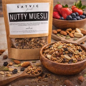 May include: A bag of Satvic Foods Nutty Muesli with a wooden bowl of muesli, a wooden spoon, and a bowl of fresh berries. The muesli is labeled as an energizing blend of organic goodness, lightly sweetened with no refined sugar.