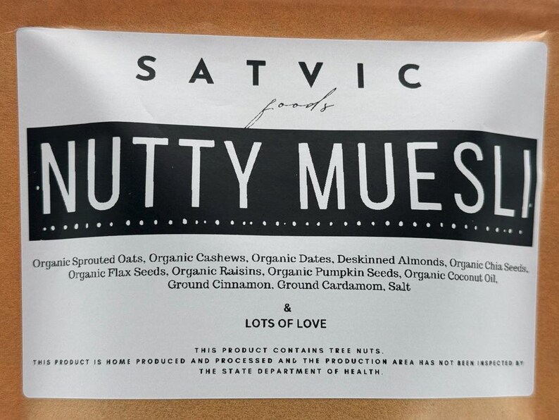 May include: A white label with the words "SATVIC foods" and "NUTTY MUESLI" in bold black letters. The label lists ingredients like organic oats, cashews, dates, and chia seeds. The text "LOTS OF LOVE" is also included.