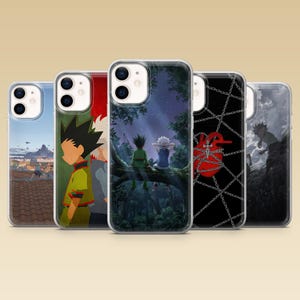 Op de afbeelding: Vijf doorzichtige telefoonhoesjes met diverse anime-geïnspireerde illustraties. De ontwerpen tonen personages op een dak, een bosscène met twee figuren op een boomtak, een rood hart omwikkeld met zilveren kettingen en een donker silhouet.