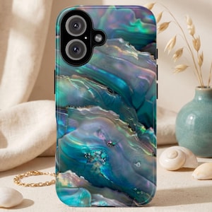 May include: A smartphone case with a swirling, iridescent design in shades of teal, blue, and purple. The case has a glossy finish and features a dual-lens camera cutout. The overall aesthetic resembles the natural patterns of abalone shells.