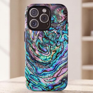 May include: A smartphone case featuring a vibrant, iridescent abalone shell pattern with swirling hues of deep blue, teal, purple, and soft pink. The design covers the entire back of the case, which includes a black camera module with three lenses.